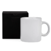Caneca branca de cerâmica ao lado de uma caixa preta
