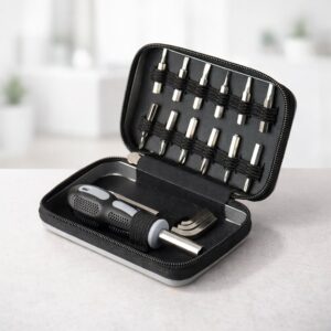 Kit de ferramentas aberto sobre uma superfície clara, com bits e chave