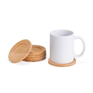 Caneca branca apoiada em um porta-copo de bambu, ao lado de outras peças do kit