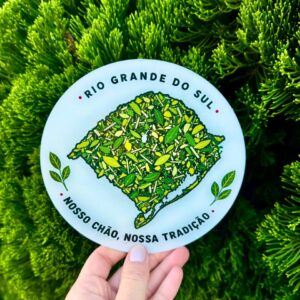 Vira-mate com estampa do mapa do Rio Grande do Sul segurado diante de folhagem